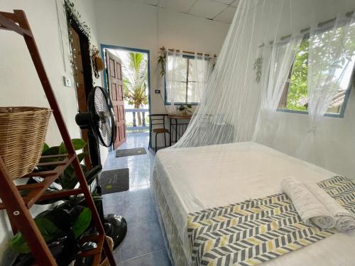 a bedroom with a bed with a mosquito net at Secret Place Hotel and Restaurant in Haad Yao