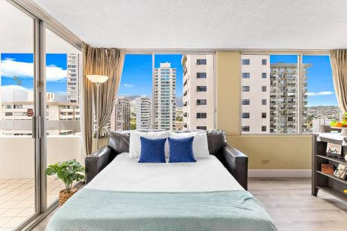 - une chambre avec un grand lit et des oreillers bleus dans l'établissement Pacific Monarch - 1 BR - Ocean and City Views!, à Honolulu