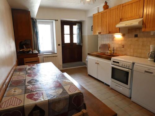- une cuisine avec des appareils électroménagers blancs et un comptoir dans l'établissement Appartement cosy 6 pers. avec balcon au village, proche parking et local à skis - FR-1-342-291, à Beaufort