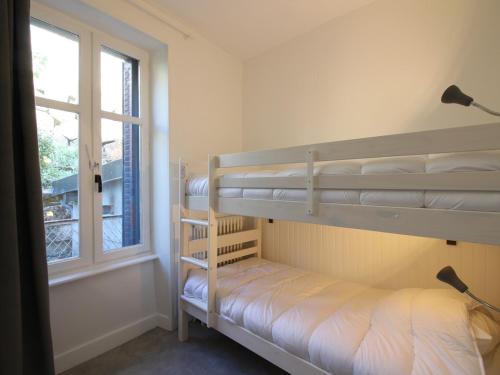two bunk beds in a room with a window at Maison La Bourboule, 5 pièces, 9 personnes - FR-1-608-237 in La Bourboule
