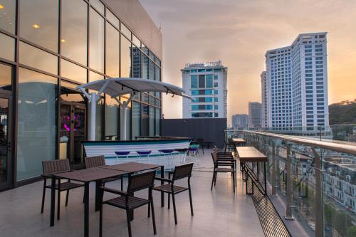 a balcony with tables and chairs on a building at Tru by Hilton Ha Long Hon Gai Centre in Ha Long