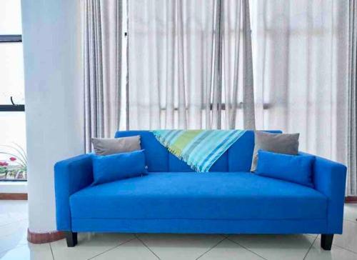 a blue couch sitting in front of a window at A 3 Cdras del Centro histórico, Amplio y en Piso 2 in Trujillo