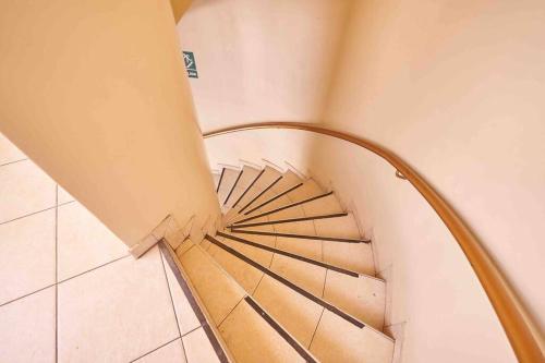 a spiral staircase in a building with a wooden railing at A 3 Cdras del Centro histórico, Amplio y en Piso 2 in Trujillo