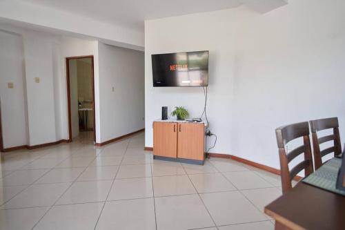 a living room with a tv on a wall at A 3 Cdras del Centro histórico, Amplio y en Piso 2 in Trujillo