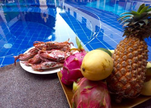 a plate of seafood next to a swimming pool at Happy Valley Pattaya in Jomtien Beach