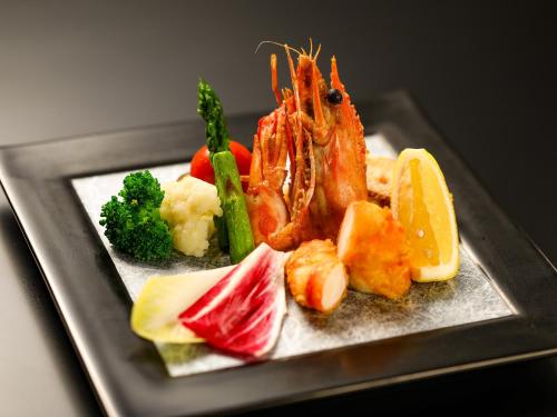 a plate of food with shrimp and vegetables on a plate at Keiryuso Siorie in Matsumoto