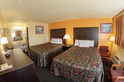 a hotel room with two beds and a desk at Knights Inn - Chanute in Chanute