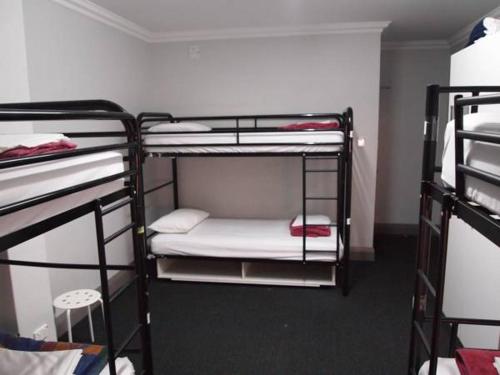 Łóżko lub łóżka piętrowe w pokoju w obiekcie The Emperors Crown Hostel
