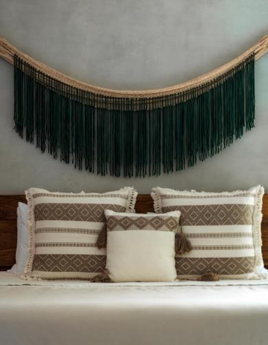 a bedroom with a bed with pillows and a headboard at San Trópico Boutique Hotel & Peaceful Escape in Puerto Vallarta