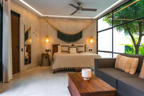a bedroom with a bed and a couch at San Trópico Boutique Hotel & Peaceful Escape in Puerto Vallarta