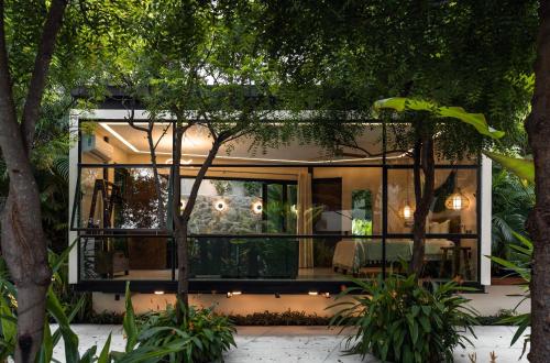 a glass house in a garden at night at San Trópico Boutique Hotel & Peaceful Escape in Puerto Vallarta