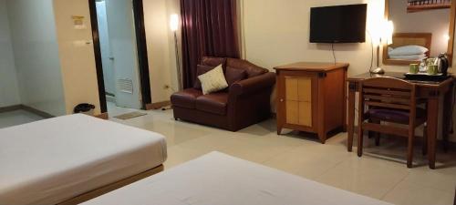 a hotel room with a bed and a chair and a desk at Hotel Celebes in Manado