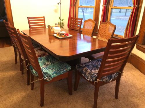 a wooden table with chairs and a plate of food on it at The Lodge Dog and Family Friendly 5 Bedrooms 13 guests 10 beds in Saint Peter