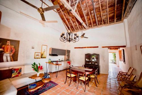 a living room with a table and chairs and a ceiling at Casa Portal de la Bodega in Mompos