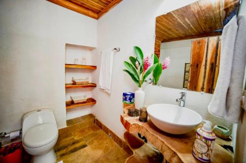 a bathroom with a sink and a toilet and a mirror at Casa Portal de la Bodega in Mompos