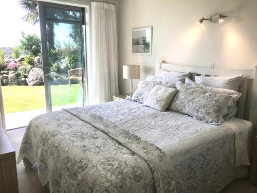 a bedroom with a bed and a large window at Sunset Point Kerikeri in Kerikeri