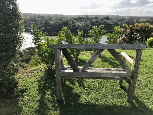 a wooden bench sitting on top of a field at Sunset Point Kerikeri in Kerikeri