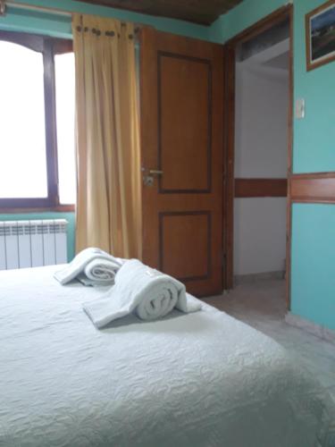 a bedroom with a bed with white towels on it at Departamentos Paisaje del Beagle in Ushuaia
