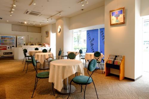un restaurante con mesas y sillas y una cocina en 2nd inn, en Osaka