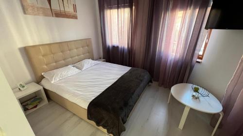 a small bedroom with a bed and a table at Downtown Studio in Bucharest