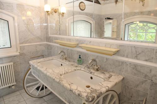 a bathroom with a sink and a large mirror at Villa Aurum in Greetsiel
