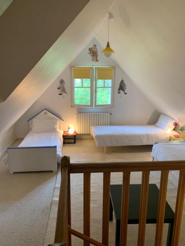 - une chambre mansardée avec 2 lits et une fenêtre dans l'établissement Villa 10-12 pers centre La Baule 300m de la Mer, à La Baule