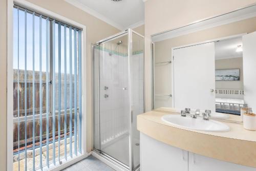波塔靈頓的住宿－Shoreside Waters，一间带水槽和淋浴及窗户的浴室