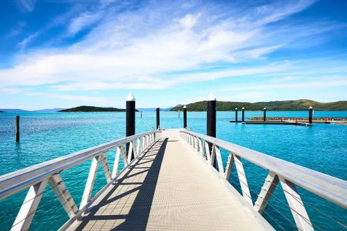 a dock in the water with a blue sky at Daydream Island Resort in Daydream Island