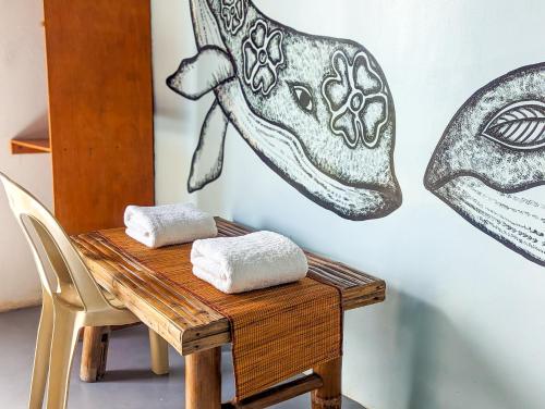 a wooden table with two towels on top of it at Lexias Hostel and Workspace - El Nido in El Nido