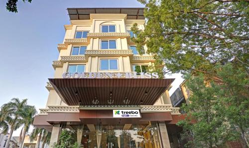 a tall yellow building with a balcony on it at Treebo Tryst Golden Bliss Trimurti Nagar Square in Nagpur