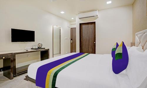 a hotel room with a bed and a television at Treebo Premium Golden Bliss Trimurti Nagar Square in Nagpur