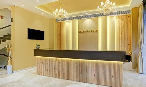 a hotel lobby with a reception desk and chandeliers at Treebo Premium Golden Bliss Trimurti Nagar Square in Nagpur