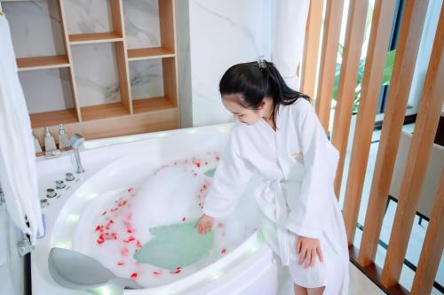 una niña pequeña parada en una bañera con sangre en ella en The King Hotel - Condotel Thai Nguyen en Thái Nguyên
