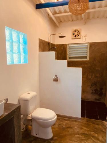 La salle de bains est pourvue de toilettes, d'un lavabo et d'une fenêtre. dans l'établissement Cafe Ceylon, à Koggala