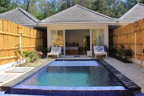 a swimming pool in the backyard of a house at Seri Resort Gili Meno - Adults Only in Gili Meno