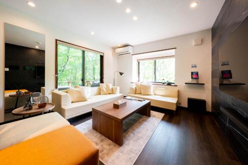 a living room with a couch and a table at Suite Villa Nasu Forest House in Nasu