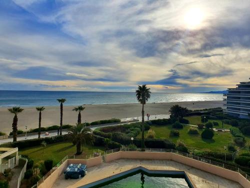 vista su una spiaggia con piscina e sull'oceano di Superbe appartement face à la mer avec parking privatif a Canet-en-Roussillon