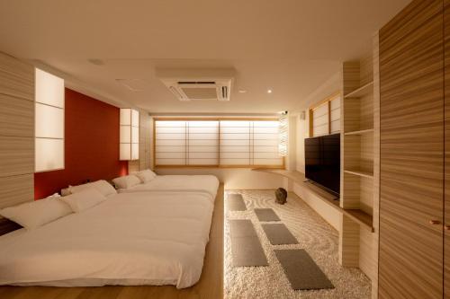 1 dormitorio con 1 cama blanca grande y TV en 夢住凛ーMu Ju Rinー en Kioto