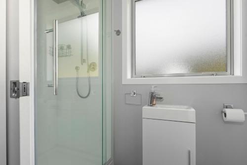 a bathroom with a shower and a sink and a mirror at Mandeno Magic - Kerikeri Holiday Home in Kerikeri
