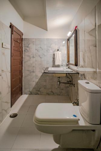 un baño con inodoro y lavabo en The Lavitra Lakeview Hotel, en Udaipur