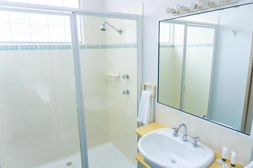 a bathroom with a shower and a sink and a mirror at Thou Walla Sunset Retreat in Soldiers Point