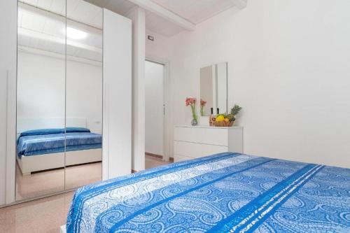 a white bedroom with a bed and a mirror at intero appartamento poseidon 46 mq in Fasano