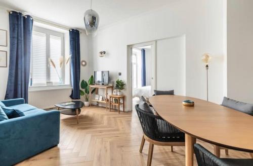 Appart Deluxe Privé Strasbourg Centre avec Parking gratuit في ستراسبورغ: غرفة معيشة مع أريكة زرقاء وطاولة