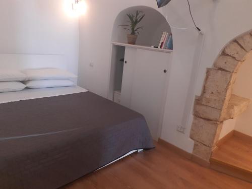 um quarto com uma cama e um arco em A Levante em Putignano