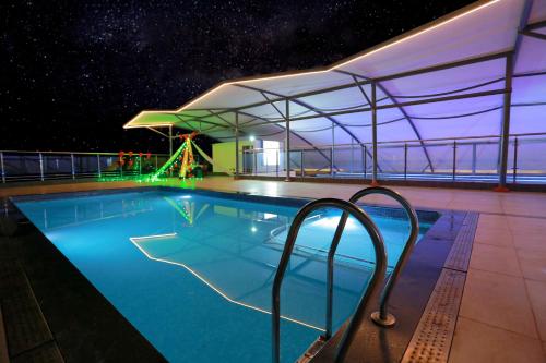 a swimming pool on a cruise ship at night at Grand Signature Hotel & spa in Yercaud