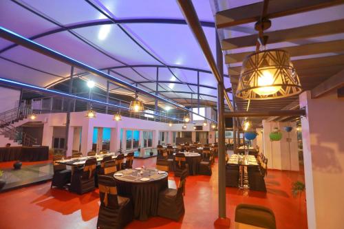 a banquet hall with tables and chairs and a ceiling at Grand Signature Hotel & spa in Yercaud