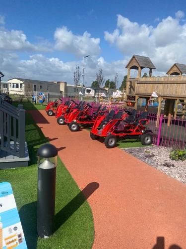 a row of red scooters parked next to a fence at Modern 3 bedroom caravan near the beach in Walton-on-the-Naze