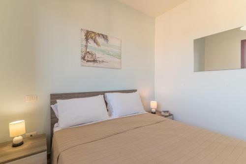 a bedroom with a bed with two pillows at Olbia Mare Apartment in Olbia