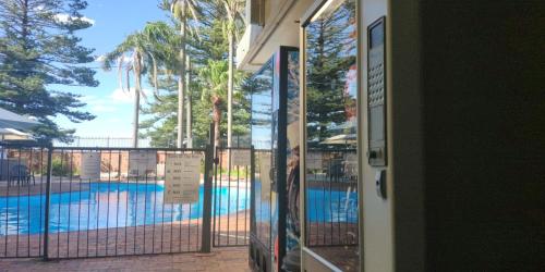 a door with a view of a swimming pool at El Lago Waters Resort in The Entrance