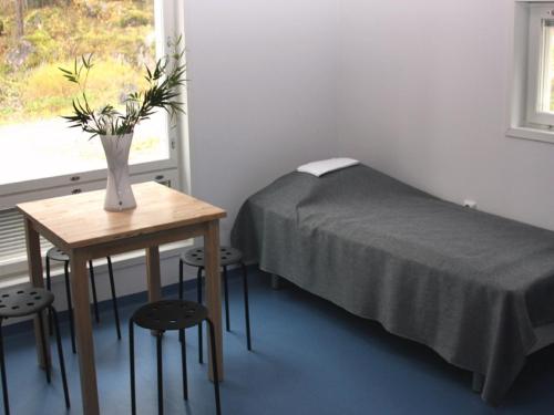 a room with a bed and a table with a vase of flowers at Rastila Camping Helsinki in Helsinki